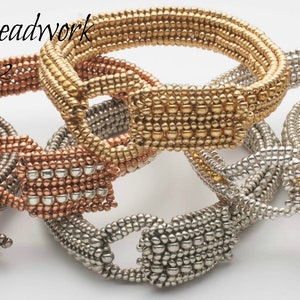 May include: Four beaded bracelets in silver, gold, and copper tones. Each bracelet has a square clasp and is made of small, evenly spaced beads.