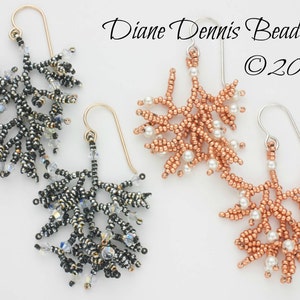 Op de afbeelding: Een paar parel oorbellen, een in zilver en zwart en de andere in koper en wit. De oorbellen zijn gevormd als takken met kleine kralen en parels.