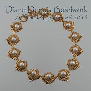 May include: A gold necklace with white pearl-like beads and a square design. The necklace is made of small beads and has a delicate, elegant look. The text "Diane Dennis Beadwork A Simple Elegance ©2016" is visible in the image.