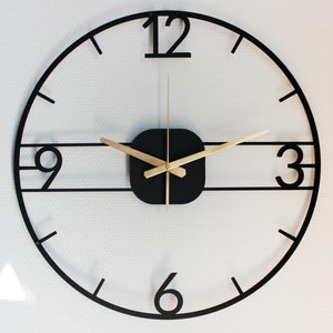 Peut inclure: Une horloge murale moderne noire et dorée avec un centre carré et des chiffres romains. L'horloge a un design minimaliste avec un cadre noir et des aiguilles dorées.