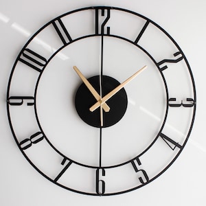 以下が含まれることがあります： ローマ数字と金色針の黒い金属製の時計。時計は透明な文字盤と黒い中心円を持っています。