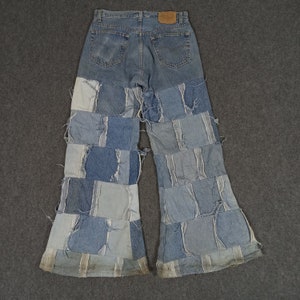 Op de afbeelding: Blauwe denim broek met wijde pijpen gemaakt van patchwork denim. De broek heeft een hoge taille en is gemaakt van verschillende tinten blauw denim.