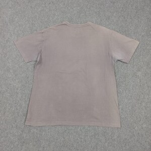 Puede incluir: Una camiseta lisa de manga corta, de color rosa empolvado. La camiseta de cuello redondo se muestra plana sobre una superficie gris, destacando su dise&ntilde;o sencillo y su estilo casual. La tela parece suave y ligeramente desgastada.