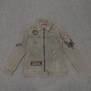 Puede incluir: Una chaqueta vaquera verde con varios parches, entre ellos "Levi Strauss & Co. Quality Never Goes Out of Style", "L.S.C. Coffee Bar", "Strange & Co. Since 1982" y "Root 7".