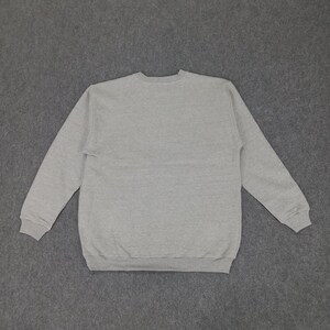 May include: A heather gray sweatshirt with a crew neck and long sleeves. The sweatshirt is made of a soft, comfortable material and is suitable for casual wear. The cuffs and hem are ribbed.