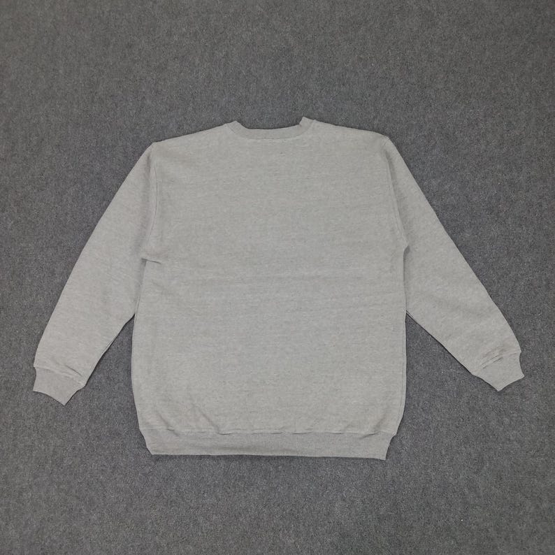 May include: A heather gray sweatshirt with a crew neck and long sleeves. The sweatshirt is made of a soft, comfortable material and is suitable for casual wear. The cuffs and hem are ribbed.