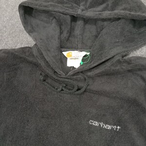 Puede incluir: Sudadera con capucha negra con un logotipo de Carhartt bordado en la parte delantera. La sudadera tiene un cord&oacute;n y un bolsillo canguro.