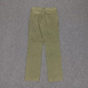 May include: A pair of olive green trousers with a button fly and belt loops.