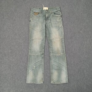 May include: Light blue denim jeans with a faded wash and distressed details. The jeans feature a classic five-pocket design, with reinforced knee panels and decorative stitching. A small tag is attached to the waistband.