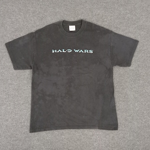 May include: Dark gray t-shirt with the text "HALO WARS" in a teal color across the chest. The shirt has a crew neck and short sleeves. The fabric appears slightly faded.