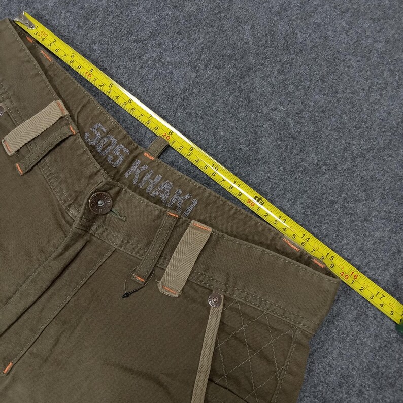 May include: A pair of olive green cargo pants with a brown leather patch that says "505 Khaki" on the waistband.
