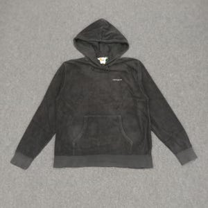 Puede incluir: Sudadera con capucha negra con un bolsillo frontal y la palabra "Carhartt" bordada en el pecho.