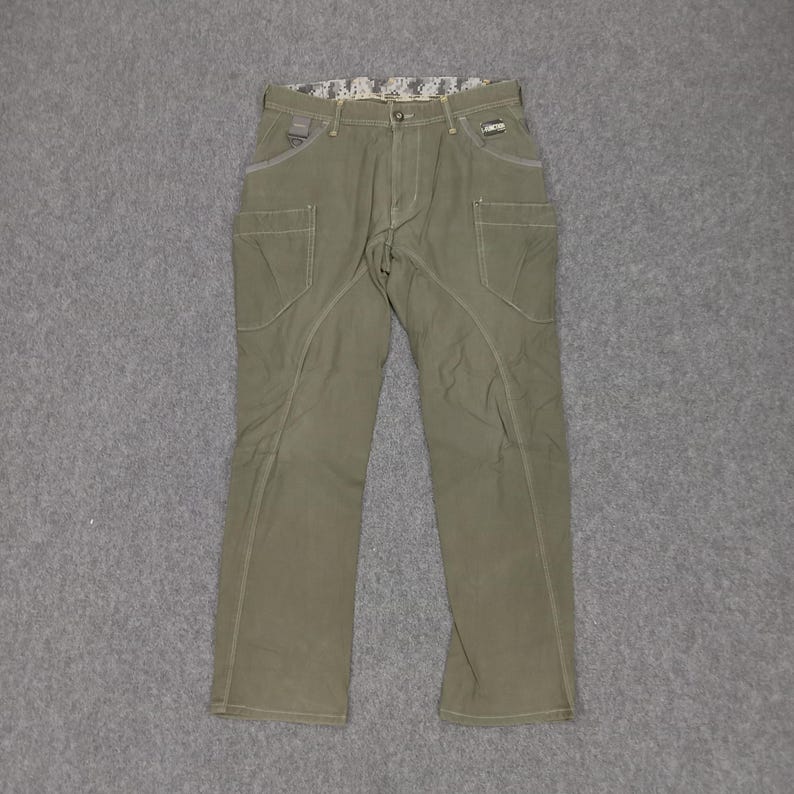 Op de afbeelding: Een olijfgroene cargo broek met meerdere zakken en een subtiel camouflagepatroon op de tailleband.