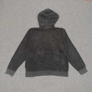 Puede incluir: Una sudadera con capucha negra con cierre de cremallera. La sudadera est&aacute; hecha de una tela suave y texturizada.