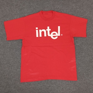 Puede incluir: Camiseta roja de manga corta con un logotipo "intel" blanco.