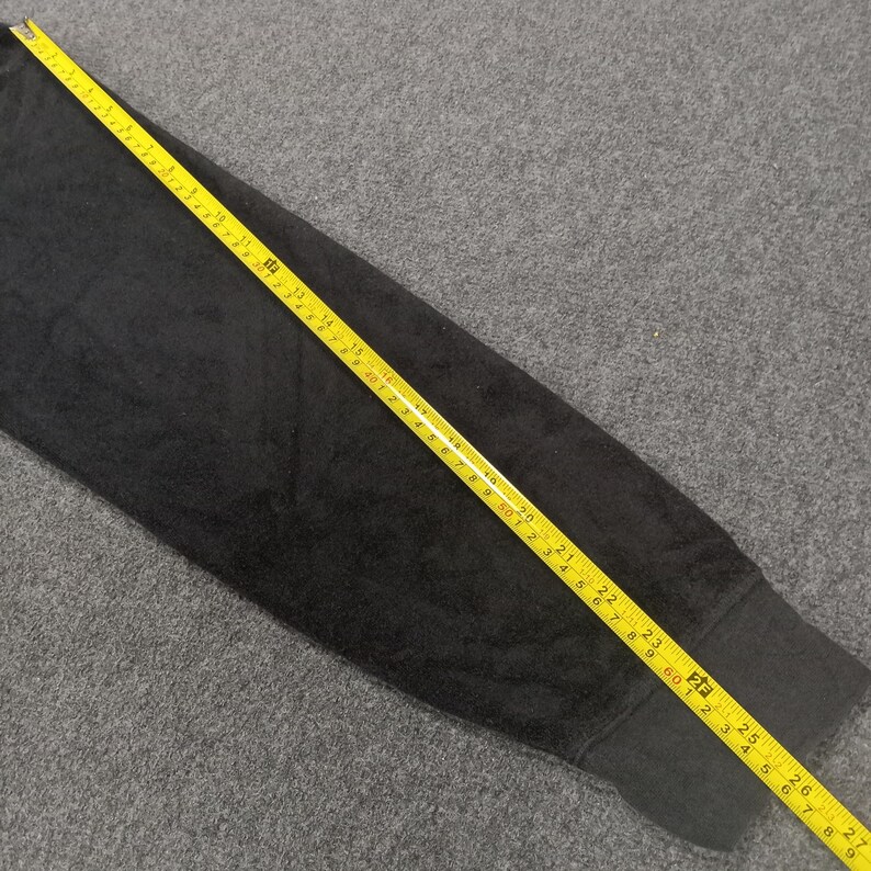 Puede incluir: Una manga de tela negra con una cinta m&eacute;trica amarilla que recorre el borde. La cinta mide hasta 71 cm.