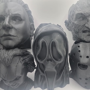 May include: Four black and white horror movie character masks. The masks are of Michael Myers, Ghostface, Jason Voorhees, and Freddy Krueger.