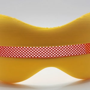 May include: A yellow plastic mask with a red mesh covering the eye area.