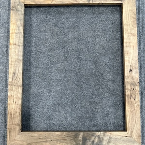 May include: A rustic wooden picture frame with a natural wood finish. The frame has a simple design with a rectangular shape and a smooth surface.