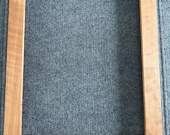 May include: A rectangular wooden picture frame with a natural wood finish. The frame is empty, showcasing the clean lines and craftsmanship of the joinery. The wood grain is visible, adding texture and warmth to the design.
