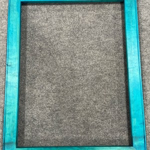 May include: A teal blue wooden picture frame with a smooth finish. The frame is empty and ready to display a photo or artwork.