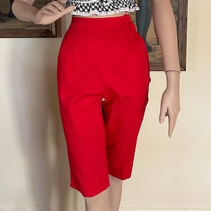 May include: A black and white gingham sleeveless top with a white lace trim and a red high-waisted pair of shorts.