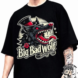 Puede incluir: Camiseta negra con una ilustración detallada de un lobo con sombrero de copa y boca abierta. El lobo tiene ojos y lengua rojos, con la inscripción "Big Bad Wolf" en una fuente estilizada. Una rosa está en la parte inferior izquierda.