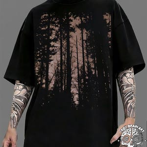 Könnte beinhalten: Schwarzes T-Shirt mit einem Waldmotiv. Das Design zeigt hohe Bäume als Silhouette vor einem hellen Hintergrund. Das T-Shirt hat kurze Ärmel und eine lockere Passform. Der Text "FRIED BRAIN ART" ist unten rechts sichtbar.