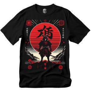 May include: Black t-shirt featuring a red and black graphic of a samurai warrior standing in front of a red sun. The design includes Japanese text and decorative elements. The shirt is a crew neck and made of a soft material.