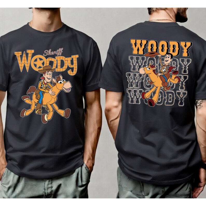 May include: Dark gray t-shirt featuring a cartoon image of Woody riding a horse. The front of the shirt has the word "Woody" in orange block letters with a star and the word "Sheriff". The back of the shirt has the word "Woody" repeated.
