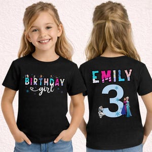 May include: Black short-sleeved t-shirt with the text "BIRTHDAY girl" in colorful letters and snowflakes. The back of the shirt has the name "EMILY" and the number "3" with characters from the movie Frozen.