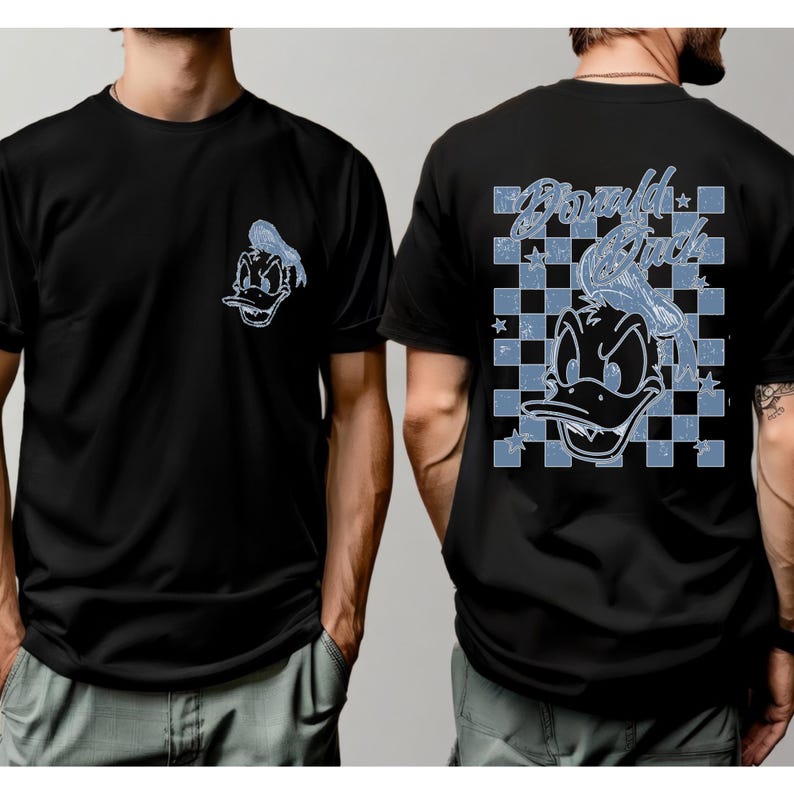 May include: Black t-shirt featuring a Donald Duck graphic on the front and back. The front graphic is a small Donald Duck head. The back graphic features a larger Donald Duck head with the words "Donald Duck" in a blue checkered design.