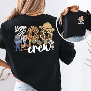 Puede incluir: Sudadera negra con el texto "Zoo Crew", n&uacute;meros con estampado animal y personajes de dibujos animados. Una imagen m&aacute;s peque&ntilde;a muestra un conejo con un sombrero con el nombre "Isabella".