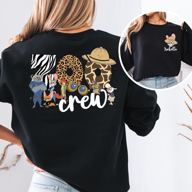 Puede incluir: Sudadera negra con el texto "Zoo Crew", n&uacute;meros con estampado animal y personajes de dibujos animados. Una imagen m&aacute;s peque&ntilde;a muestra un conejo con un sombrero con el nombre "Isabella".