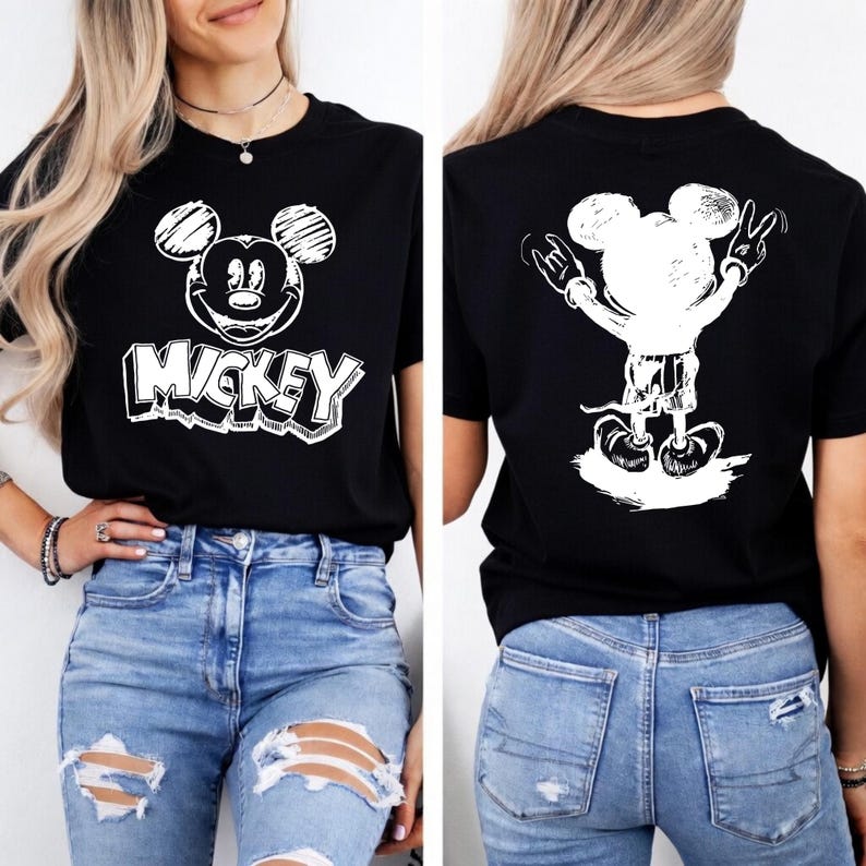 May include: Black t-shirt featuring a white Mickey Mouse graphic on the front and back. The front design includes the word "Mickey" in a bold, outlined font. The back shows Mickey with his arms raised in a rock and roll gesture.
