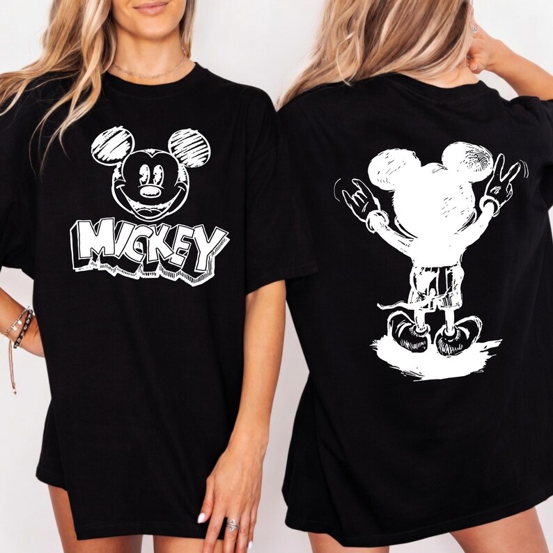 May include: Black t-shirts with a white Mickey Mouse graphic. One shirt features Mickey's face with the word "Mickey" below. The other shirt shows Mickey with his arms up in a rock and roll pose.