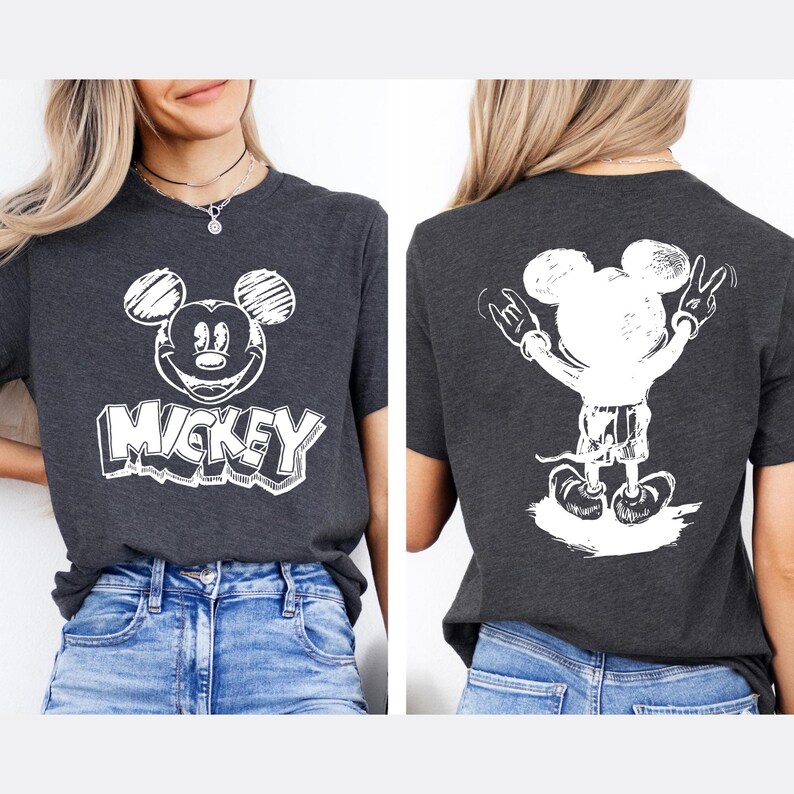 May include: Dark gray t-shirt featuring a white Mickey Mouse graphic on the front and back. The front design includes Mickey's face and the word "Mickey" in a bold font. The back shows Mickey with his arms up in a peace sign.