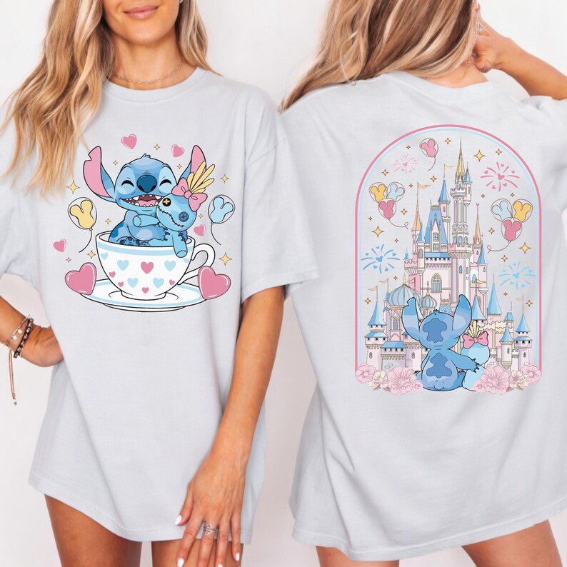 May include: Light blue t-shirt featuring a cartoon Stitch design. The front shows Stitch in a teacup with hearts and balloons. The back displays Stitch in front of a castle with fireworks and flowers. A fun, whimsical design.