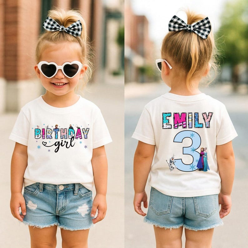 May include: A white t-shirt with the text "BIRTHDAY girl" in colorful letters and a blue and purple design. The back of the shirt has the name "EMILY" and the number "3" with cartoon characters. The child is wearing denim shorts and heart-shaped sunglasses.
