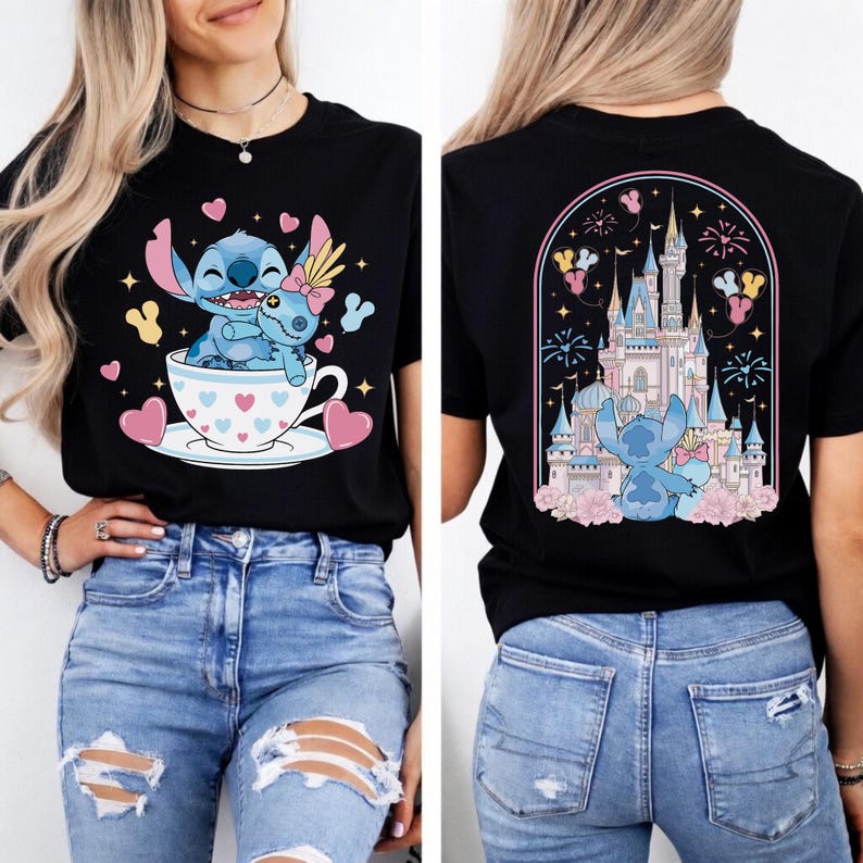 May include: Black t-shirt featuring a cartoon Stitch character in a teacup with a friend, surrounded by hearts and stars. The back of the shirt shows Stitch in front of a castle with fireworks and flowers. The design is in shades of blue, pink, and yellow.