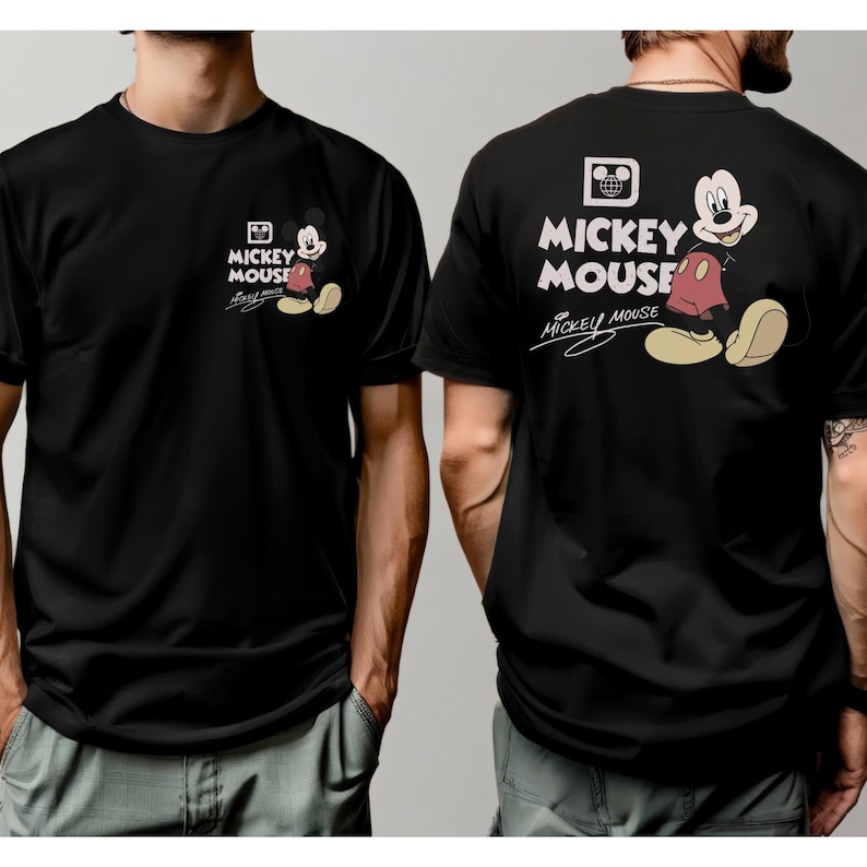 May include: Black t-shirt featuring Mickey Mouse. The front displays a small Mickey Mouse graphic with the words "Mickey Mouse" and signature. The back has a larger Mickey Mouse graphic with the words "Mickey Mouse" in white.