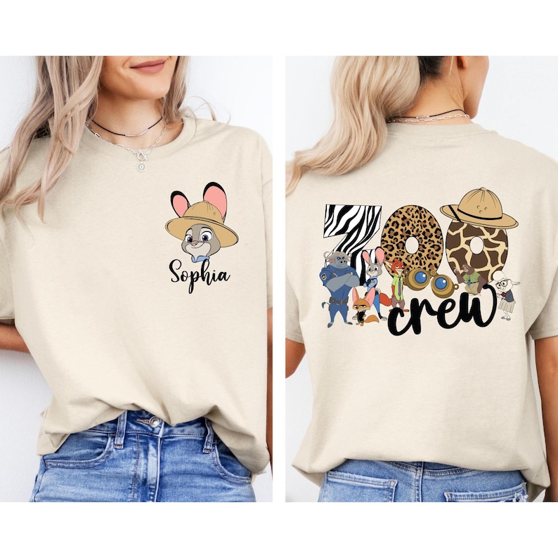 Puede incluir: Camiseta beige con un conejo de dibujos animados con sombrero de safari y el nombre "Sophia". La parte trasera de la camiseta muestra "Zoo Crew" con n&uacute;meros con estampado animal y personajes de dibujos animados.