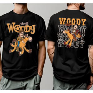 May include: Black t-shirts featuring a cartoon image of Woody riding a horse. The front of the shirt has the word "Woody" in a yellow and orange design, with "Sheriff" above. The back of the shirt has the word "Woody" repeated.