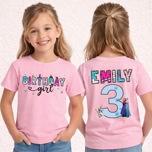 May include: Pink short-sleeved t-shirt with the text "BIRTHDAY girl" in a colorful, glittery font on the front. The back of the shirt features the name "EMILY" and the number "3" with cartoon characters.