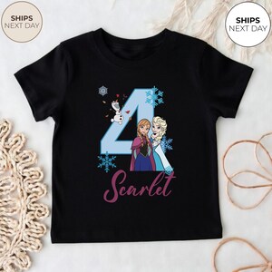 May include: Black t-shirt with a light blue number 4 design, snowflakes, and cartoon characters Anna, Elsa, and Olaf from Frozen. The name "Scarlet" is written in cursive below the number.