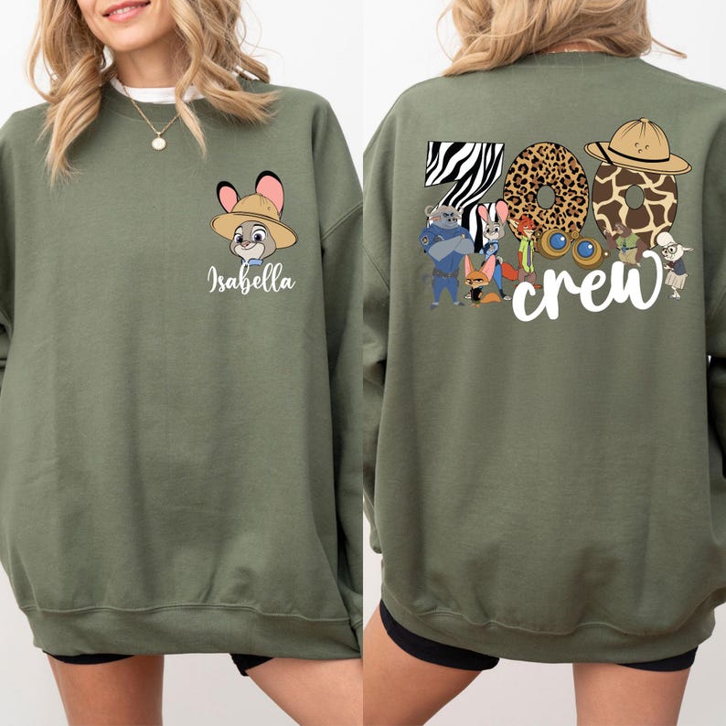 Puede incluir: Sudadera verde oliva con un conejo de dibujos animados con un sombrero de safari y el nombre "Isabella" debajo. La parte trasera muestra "Zoo Crew" con n&uacute;meros con estampado animal y personajes de dibujos animados.