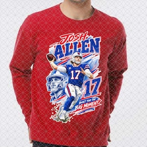 May include: A red long-sleeve shirt featuring a graphic of football player Josh Allen in a blue uniform with the number 17. The design includes the text JOSH ALLEN, the number 17, and the phrase BUILT FOR THE BIG MOMENT in blue and white.