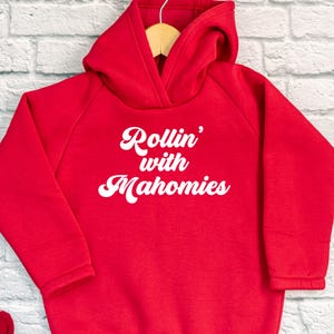May include: Red hooded sweatshirt with white text that reads "Rollin' with Mahomes".
