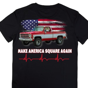 May include: Black t-shirt with a red, white, and blue American flag design. A red pickup truck is in front of the flag. The text "Make America Square Again" is printed below the truck. A red heartbeat graphic is below the text.