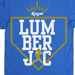 May include: Royal blue t-shirt with a gold and white graphic. The graphic features the word "LUMBERJACKS" in large white letters, a baseball player silhouette, and the word "Royal" above.
